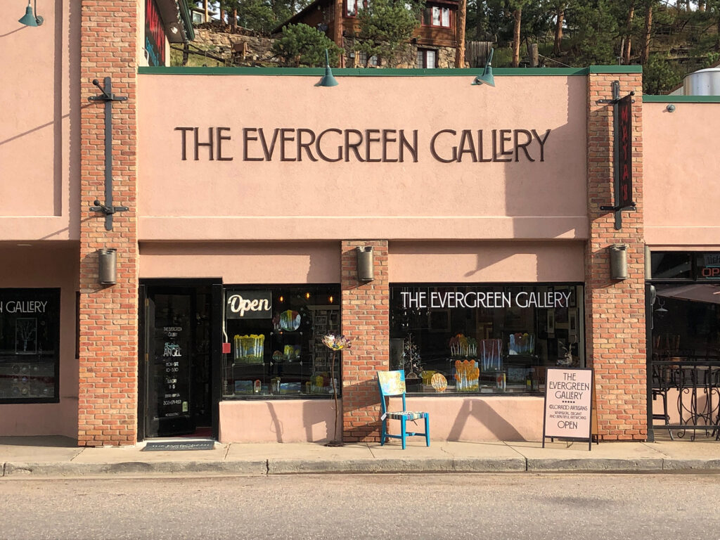 This photo shows the storefront of The Evergreen Gallery on the Historic Main Street of Downtown Evergreen, Colorado. 