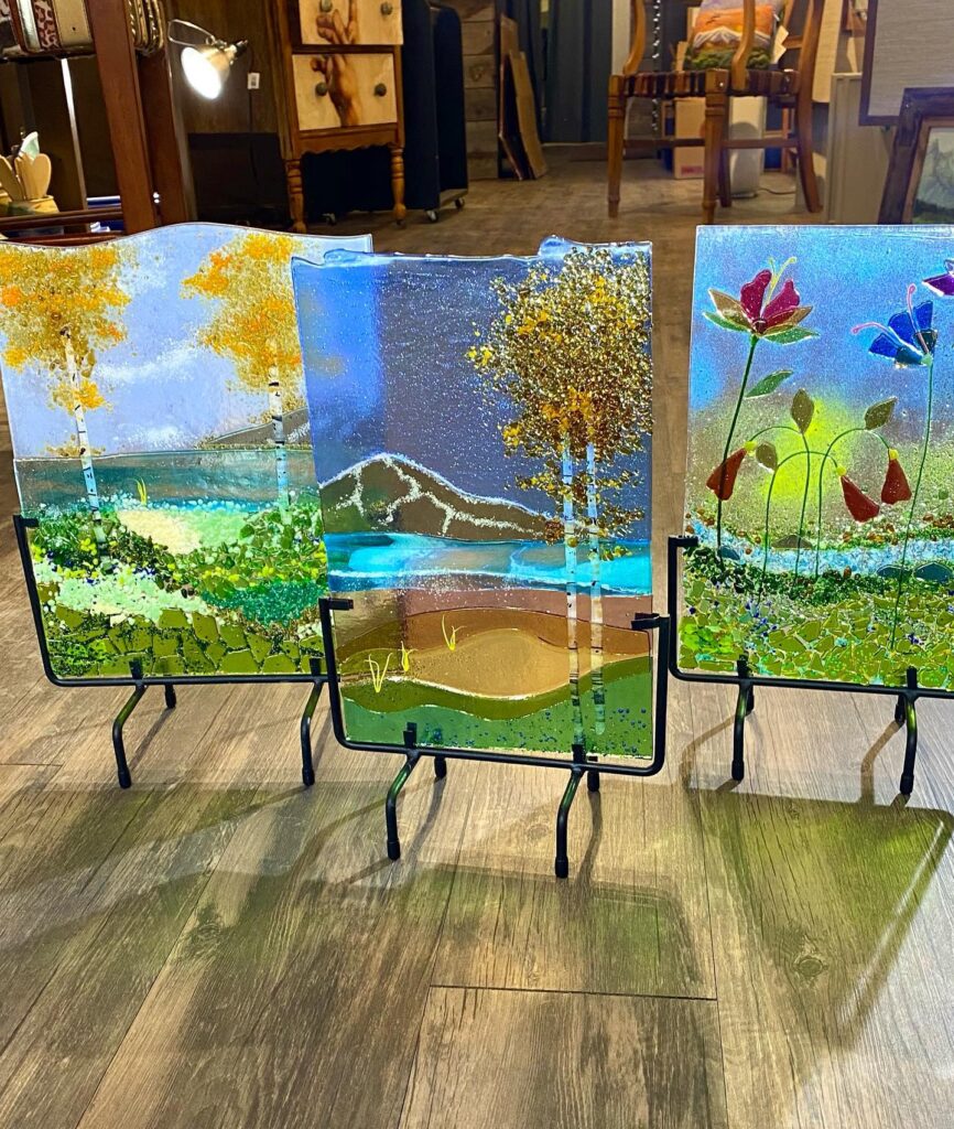 Three fused glass pieces made by Michelle Manquen. Flower and Aspen Mountain scenes.