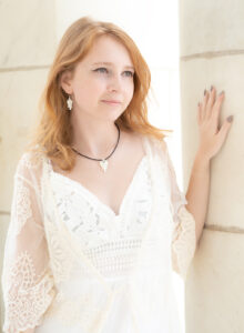 A redheaded woman wearing the Evergreen Angel Jewelry Collection